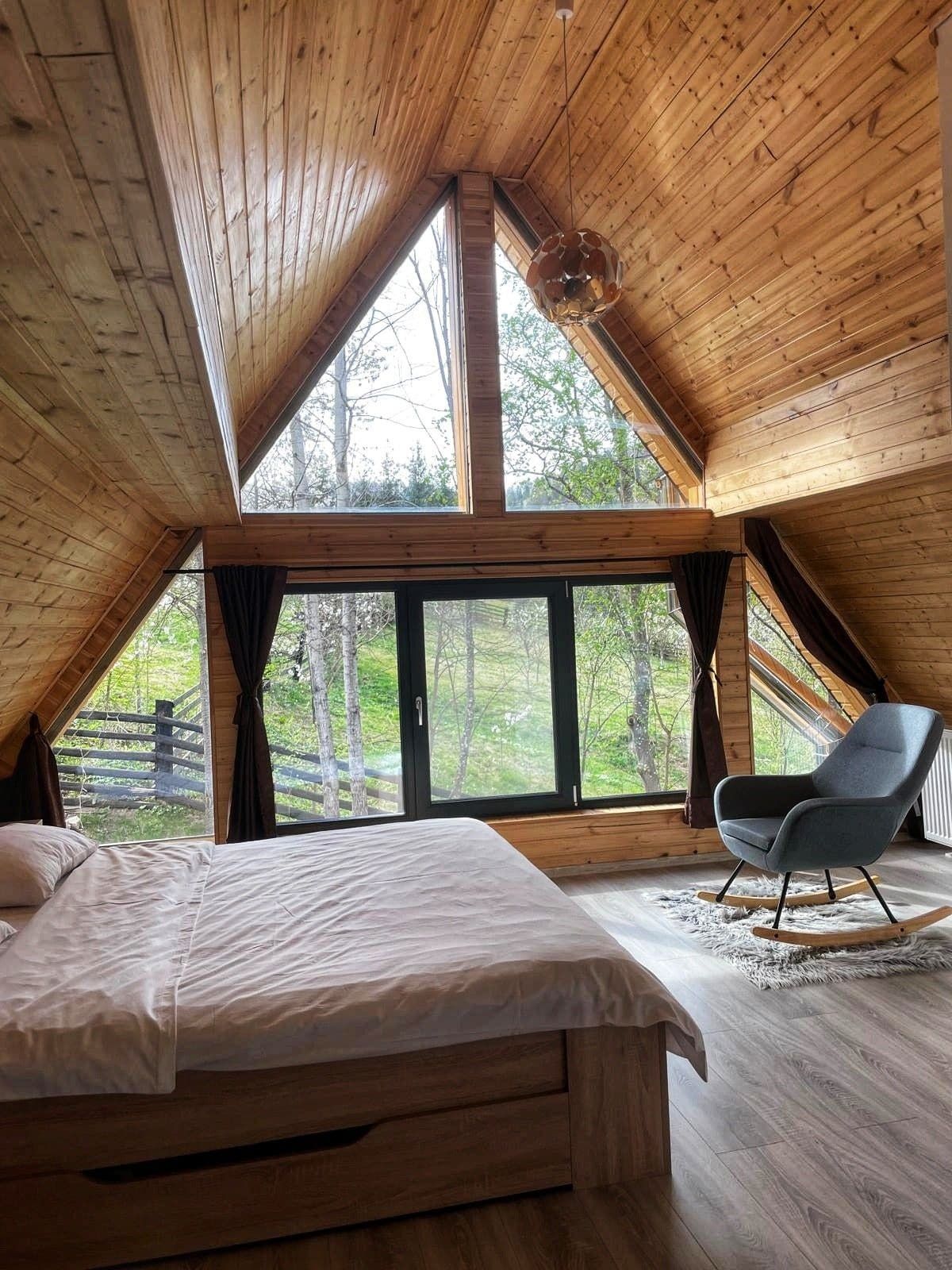 Inside the Green View Rarău A-Frame cabin: warm wood and a panoramic window